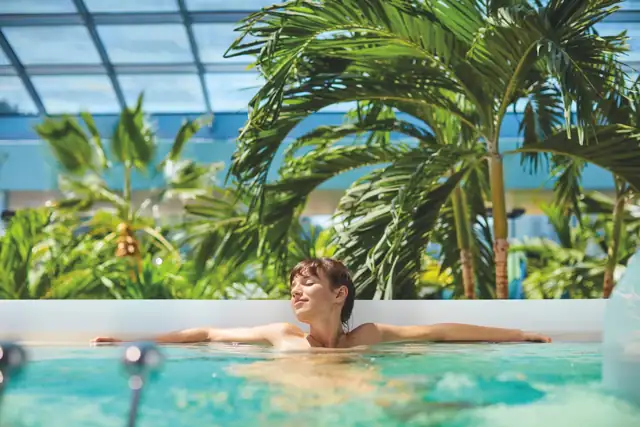 Frau entspannt im Wasser in der Palmenoase im Badeparadies Schwarzwald.