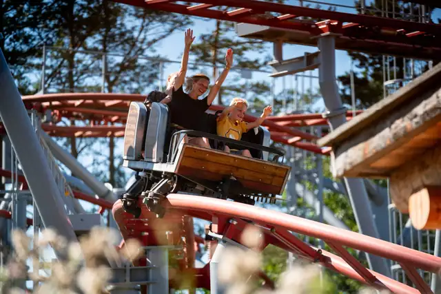 Familie sitzt in einer Achterbahn und hat Spaß. Der Freizeitpark Tatzmania kann mit der Hochschwarzwald Card kostenlos besucht werden.