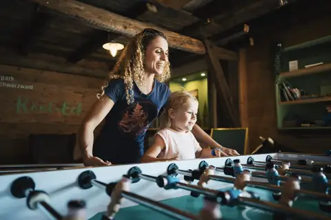Mutter und Tochter spielen Tischkicker im Innenbereich des Spaßparks Hochschwarzwald