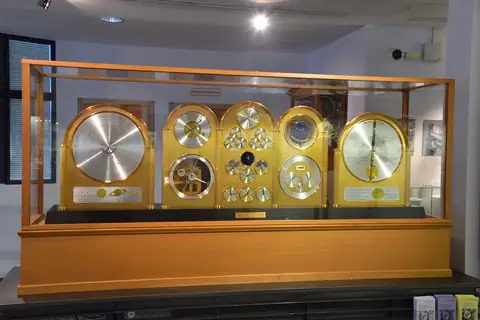 Vier historische Präzisionsuhren in einer Glasvitrine aus Holz, Deutsches Uhrenmuseum