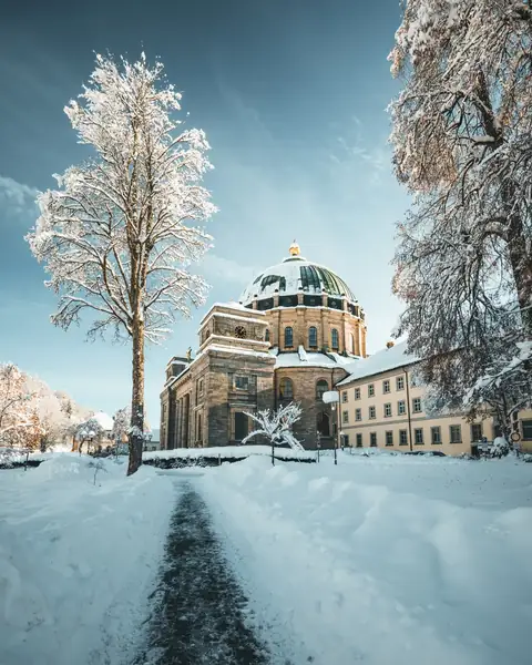 Winterlicher Dom St. Blasien mit verschneiter Kuppel und Bäumen im Vordergrund