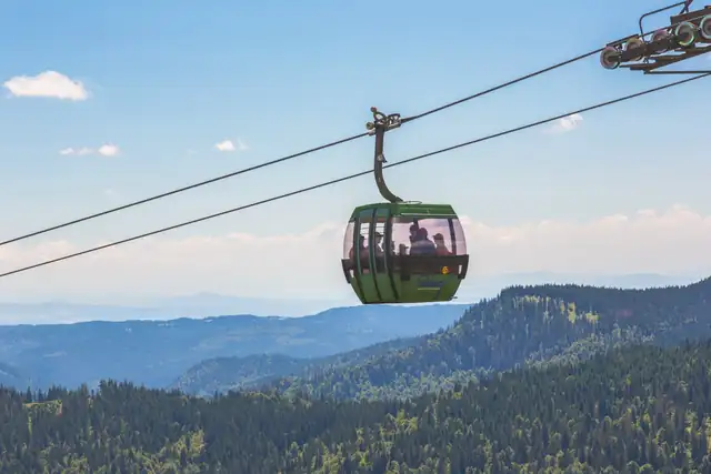 Gondel der Feldbergbahn über bewaldeten Hängen, im Hintergrund die Schwarzwaldkette