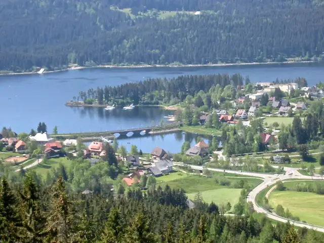 Luftaufnahme von Schluchsee mit Brücke, Ufersiedlung und Wald, kein Minigolf erkennbar