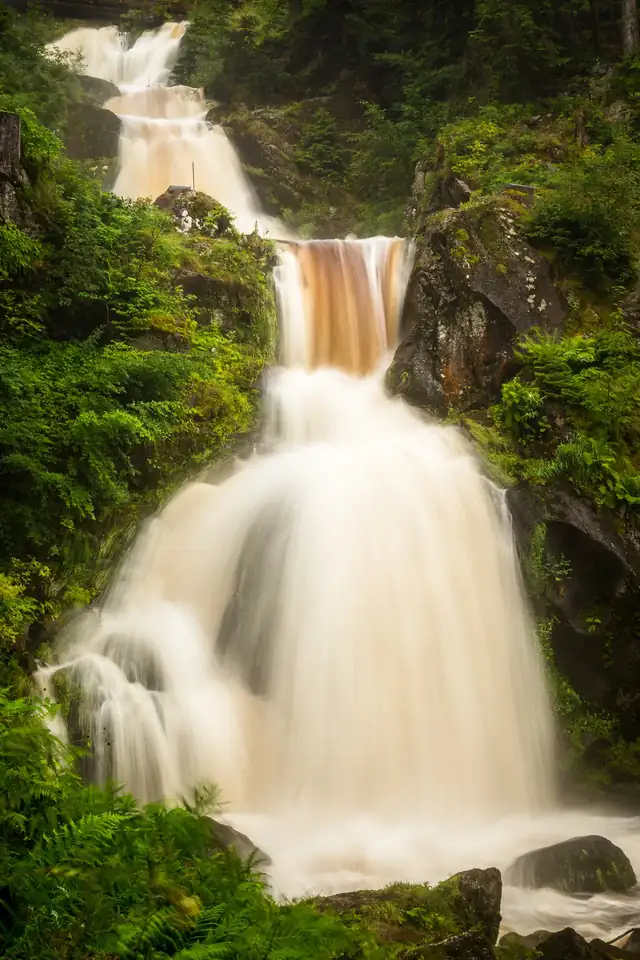 Triberger Wasserfälle mit mehreren Kaskaden über bemooste Felsen, umgeben von üppigem Grün