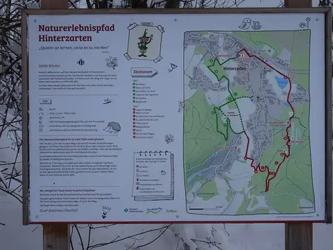 Infotafel zum Naturerlebnispfad Hinterzarten mit Routenkarte und Stationsbeschreibungen im Winter