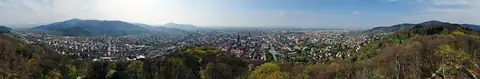 Panoramablick vom Schlossberg über die Freiburger Innenstadt mit Münsterturm und umliegenden Hügeln