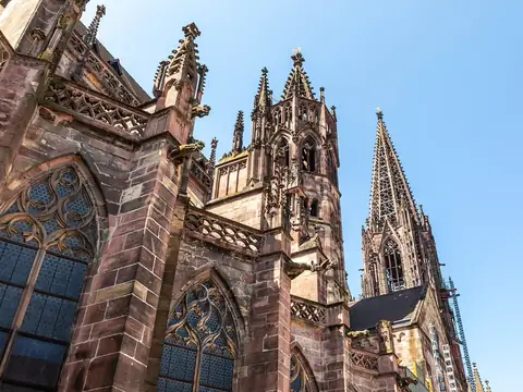 Freiburger Münster, gotische Türme und Maßwerk aus rotem Sandstein vor blauem Himmel