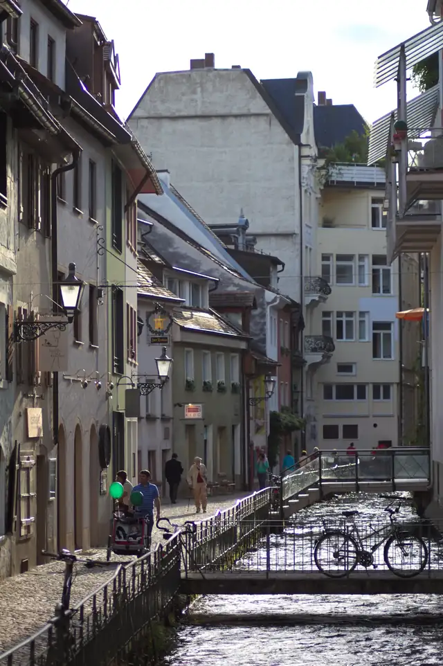 Historische Gasse entlang des Freiburger Bächles mit Kopfsteinpflaster und Fachwerkgebäuden