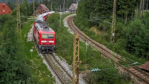 DB-Regionalzug (Baureihe 143) fährt durch Waldkurve bei Bahnhof Feldberg-Bärenthal