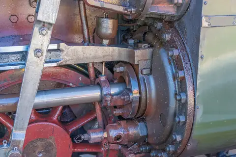 Nahaufnahme von Rädern, Kolbenstange und Antriebstechnik einer Dampflokomotive