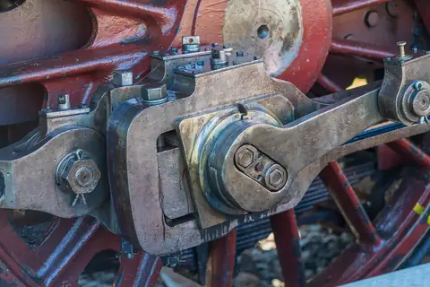 Nahaufnahme des Kuppelstangen- und Radantriebs einer historischen Dampflokomotive