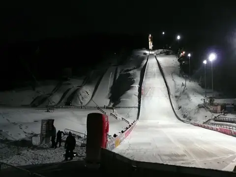 Adlerschanze Hinterzarten bei Nacht, beleuchtete Anlaufspur und Schanzentisch im Flutlicht