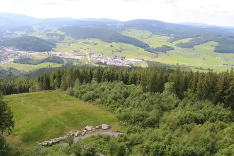 Aussicht vom Hochfirstturm über Waldwiesen und Täler mit Ortschaft im Schwarzwald