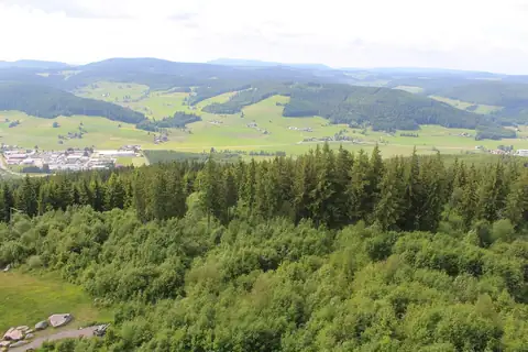Panoramablick vom Hochfirstturm über Wald, Wiesen und ein Dorf im Tal