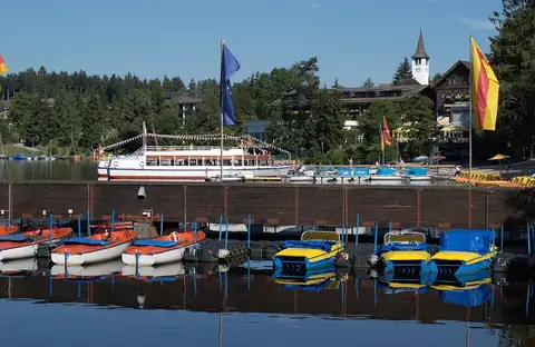 Titisee-Ufer mit Ausflugsboot, Tretbooten und Bootsverleih vor Ortspanorama