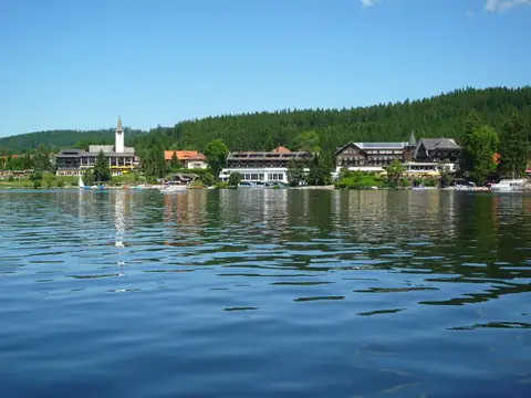 Titisee mit Ufersilhouette aus Hotels und Kirchturm im Schwarzwald