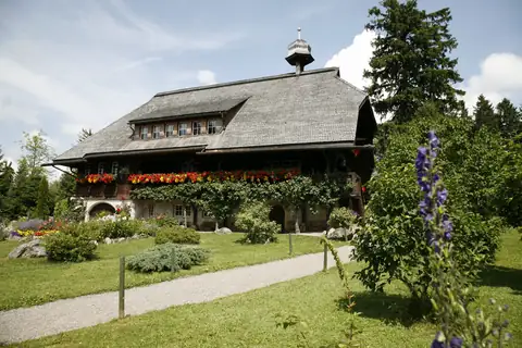 Heimatmuseum Hüsli von außen mit üppig bepflanztem Garten im Sommer