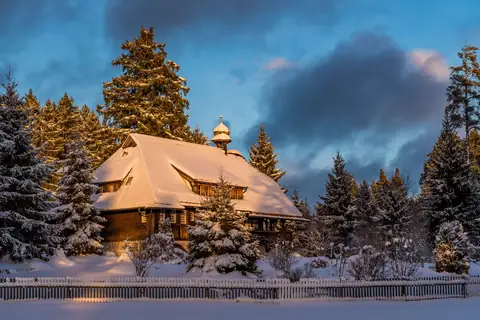 Das verschneite Hüsli in der Abenddämmerung, Seitenansicht im Winter