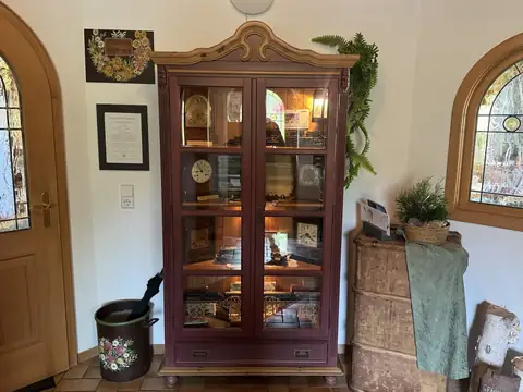 Beleuchtete Vitrine mit alten Uhren und Modelleisenbahn im Eingangsbereich des Cafés
