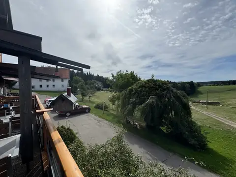 Aussicht vom Balkon auf Garten, Zufahrt und Weiden rund um das Café
