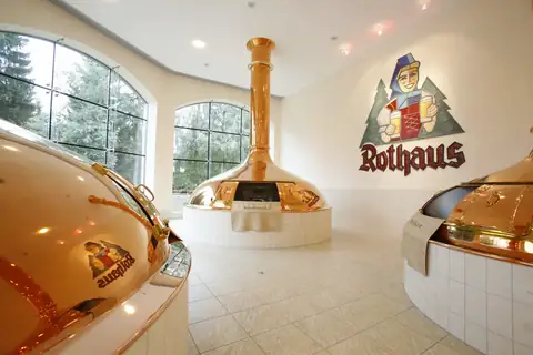 Glänzende Kupferkessel im Rothaus Brauereimuseum mit Rothaus-Logo an der Wand