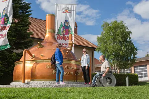 Begehbarer Kupferkessel-Nachbau vor der Rothaus Brauerei, barrierefrei zugänglich mit Rollstuhlfahrer