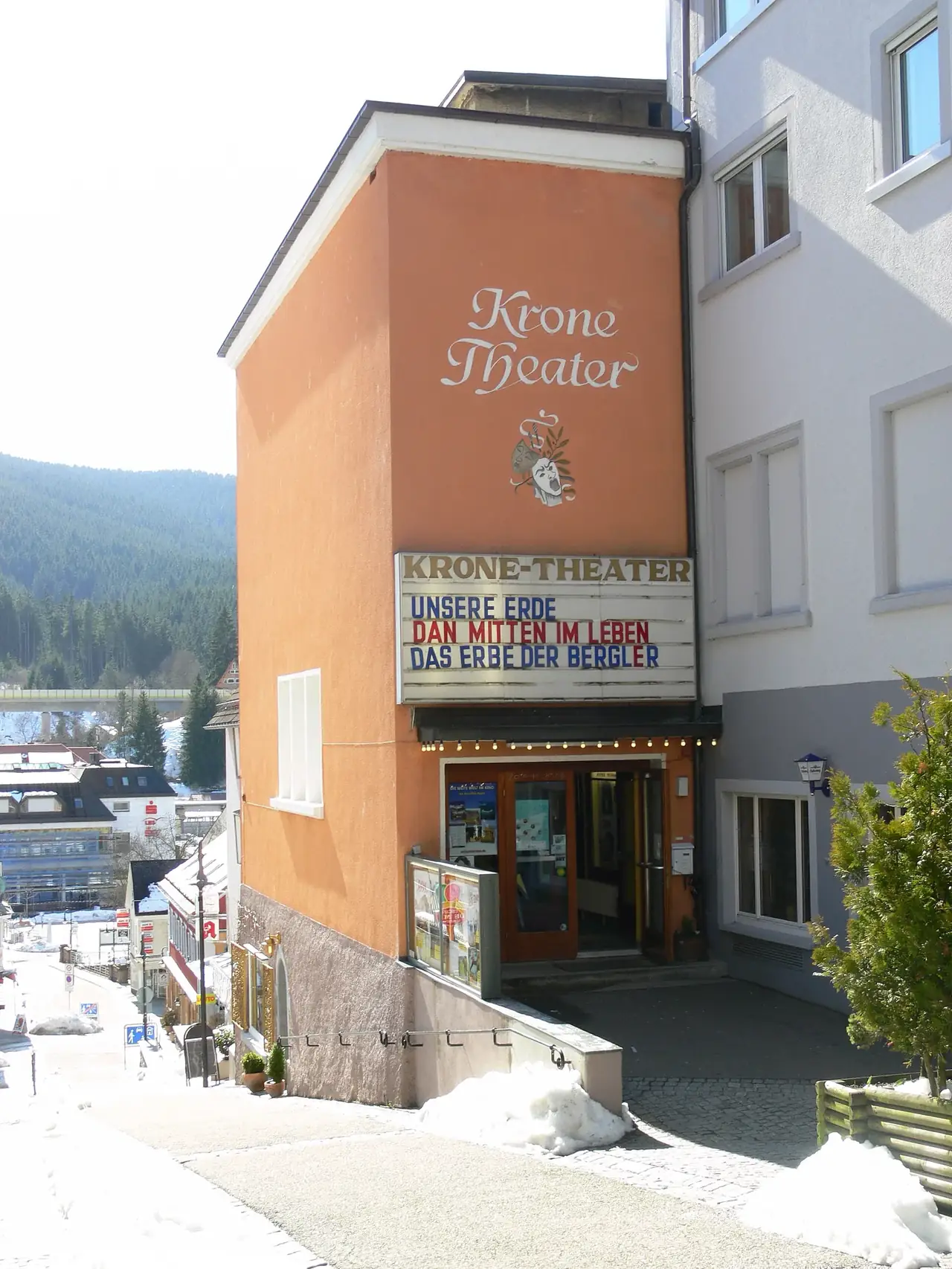 Fassade des Krone-Theaters in Neustadt mit Kinoprogramm-Anschlagtafel im Winter