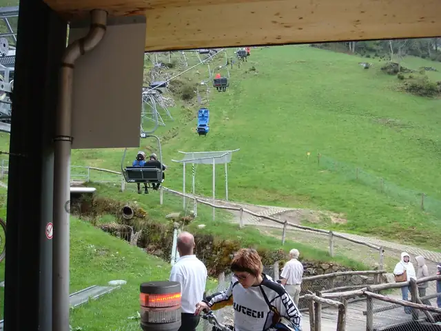 Bike-Lift im Bikepark Todtnau: Mountainbiker fahren auf Sessellift den Hang hinauf, grüne Wiesen