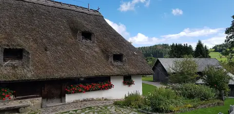 Strohgedecktes Schwarzwaldhaus mit roten Geranien am Freilichtmuseum Klausenhof Herrischried