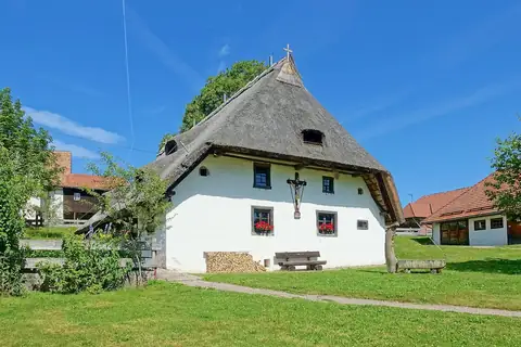 Historisches Bauernhaus mit Strohdach im Freilichtmuseum Klausenhof, Herrischried, bei blauem Himmel